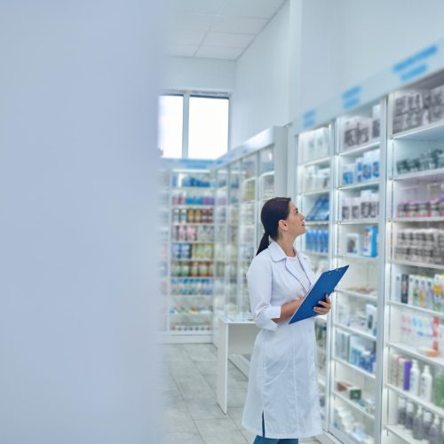 pharmacist checking medicines drugstore for inventory management systems